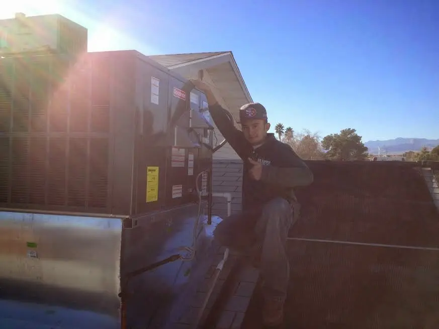 HVAC technician performing AC Tune-Up on a rooftop unit in Rockaway